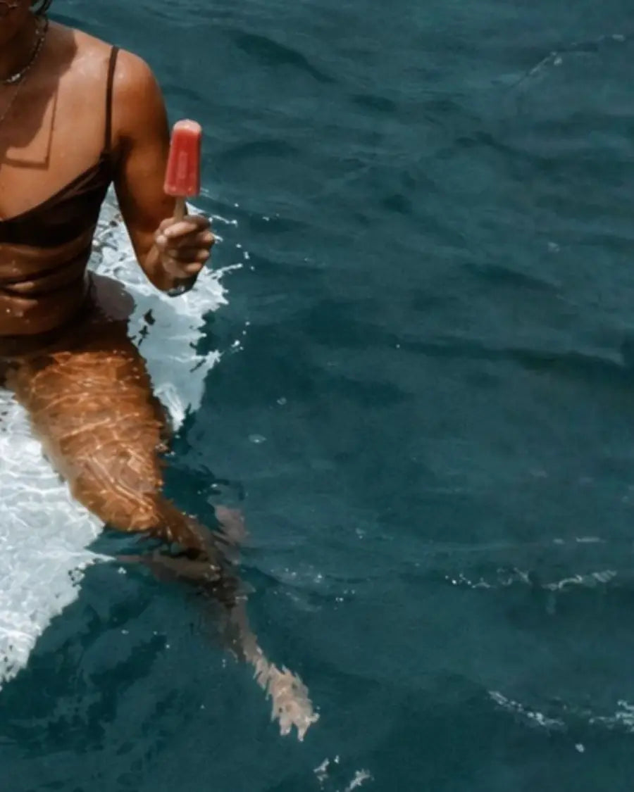 A swimmer enjoying a frozen pop in deep blue water